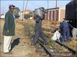 Der Vorarbeiter koordiniert die einzelnen Arbeitsschritte ohne sich die Finger schmutzig zu machen. Bekohlen der Malletlok mit Muskelkraft in Asmara. (28.10.2008)